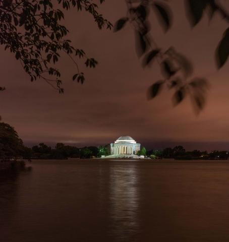 washington monument lit up at night from across a body of water