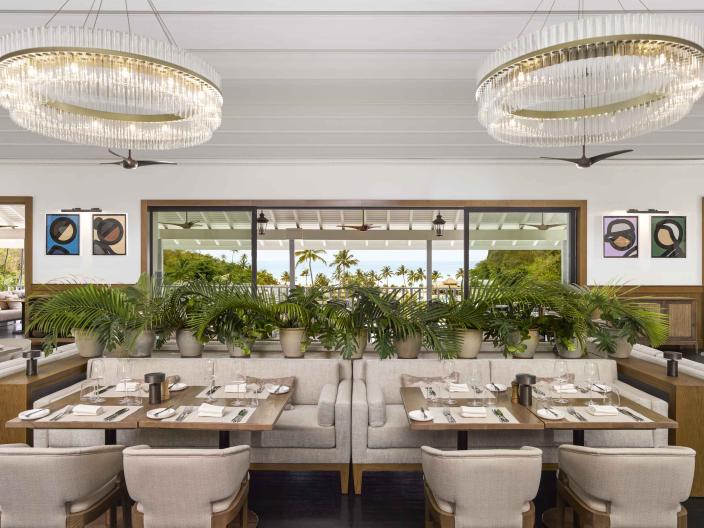 The dining room of Saltwood Restaurant at Sugar Beach, with several booths and a view of the beach