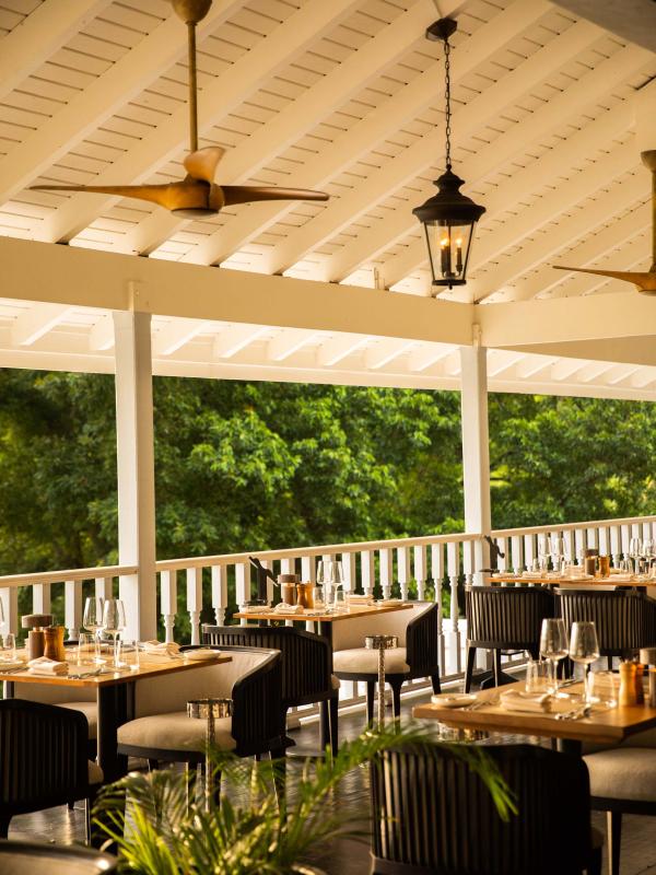 A covered patio dining room in the afternoon sun.