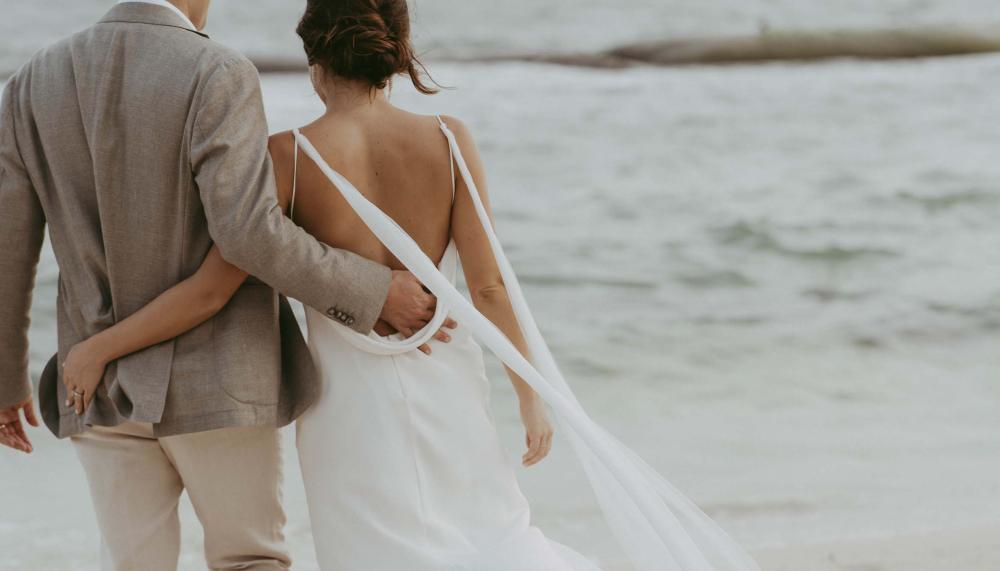Bride and groom walking on the beach