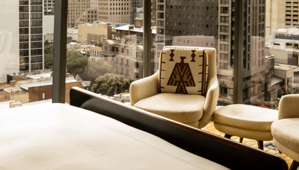 A chair against the floor to ceiling windows in a room at Viceroy Chicago