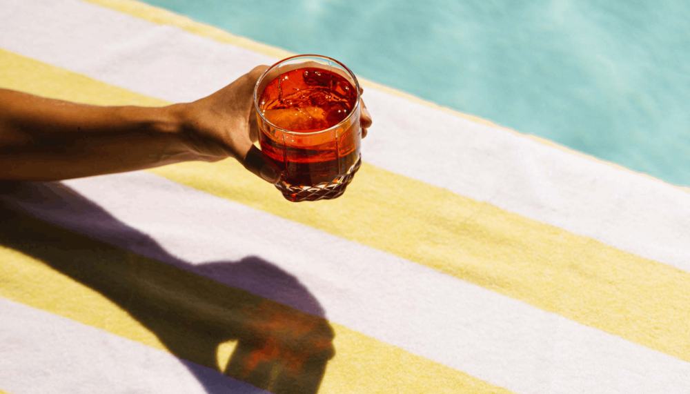 An arm holding a cocktail poolside at Viceroy Washington