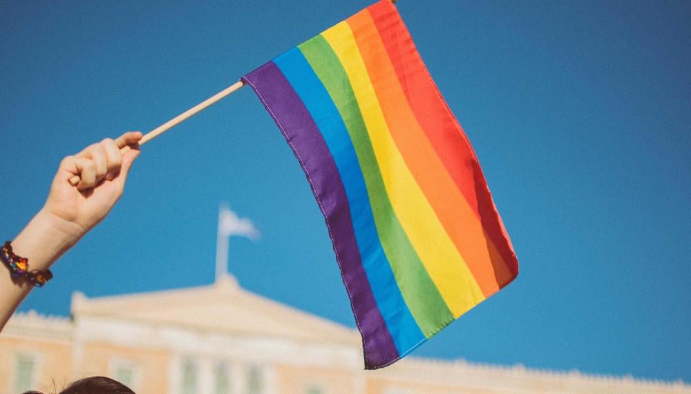 A person waving a pride flag at the pride parade near Viceroy Zena Washington DC