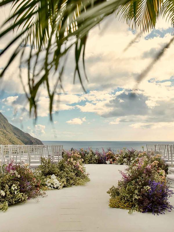 chairs set up in rows with floral arrangements placed on aisle for wedding