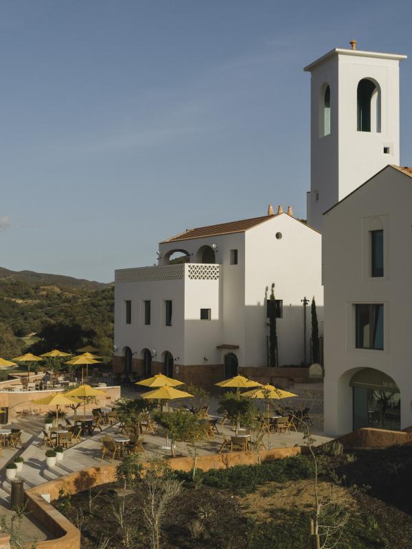 Exterior of the Viceroy Ombria Algarve Hotel with a bunch of yellow umbrellas on a patio space
