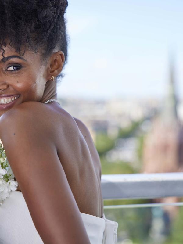 A woman in a wedding dress smiling over her shoulder