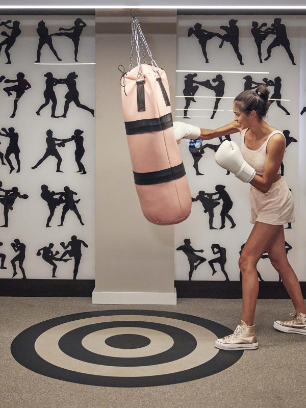 A woman punching a pink boxing bag
