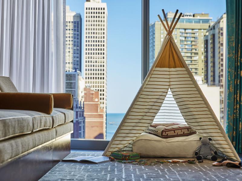 Teepee-style children's pop-tent set up in a hotel room looking out on the Chicago skyline