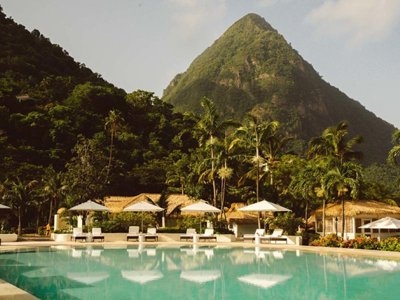 A pool and cabanas at the foot of two mountains at Sugar Beach